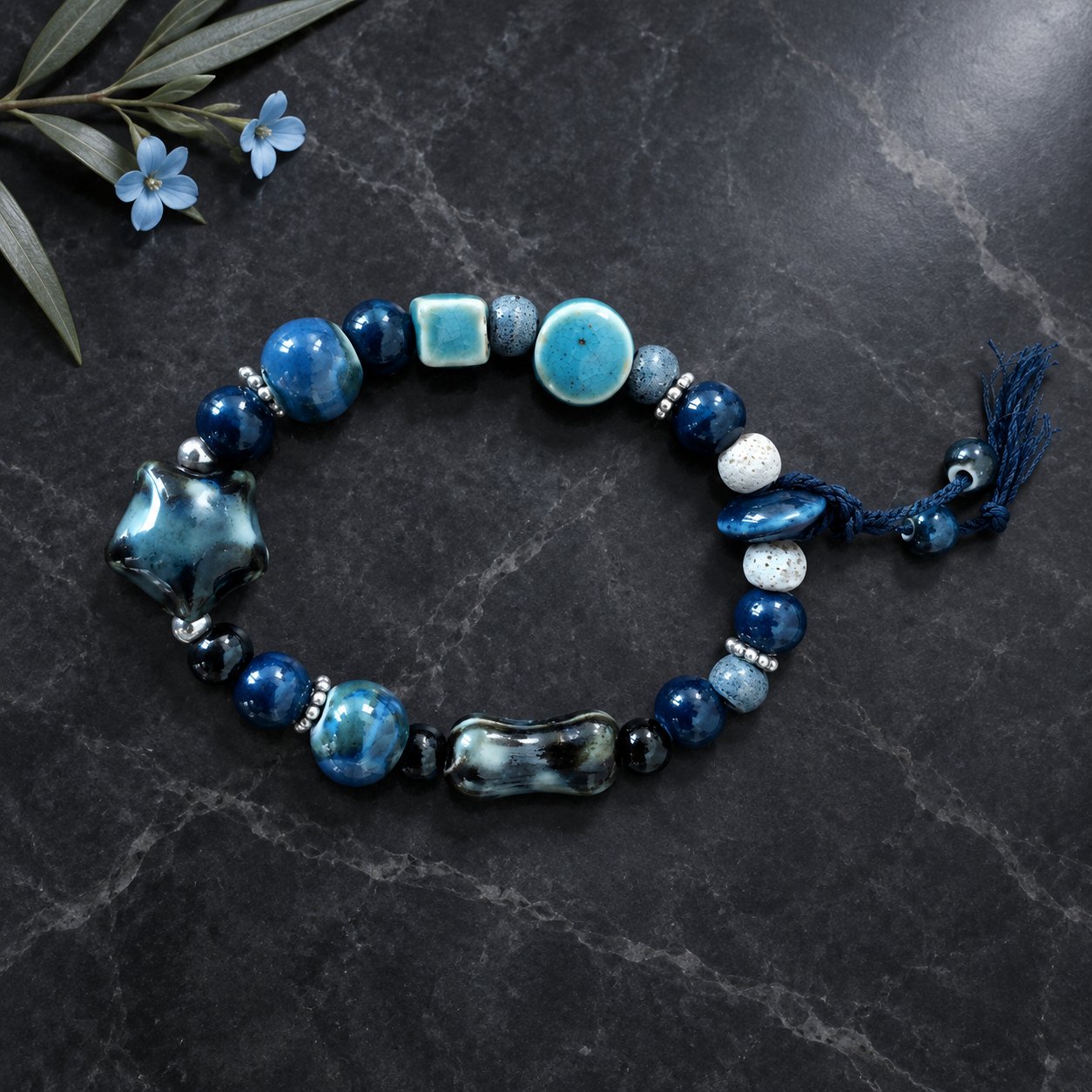 Tide Memory — ocean blue hand-glazed ceramic beaded bracelet on black marble